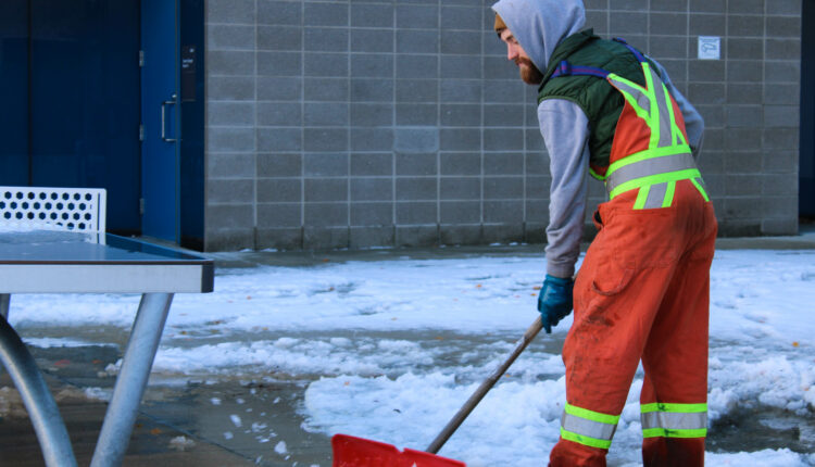 Workers keep up with the snowfall in Vancouver on Nov 30