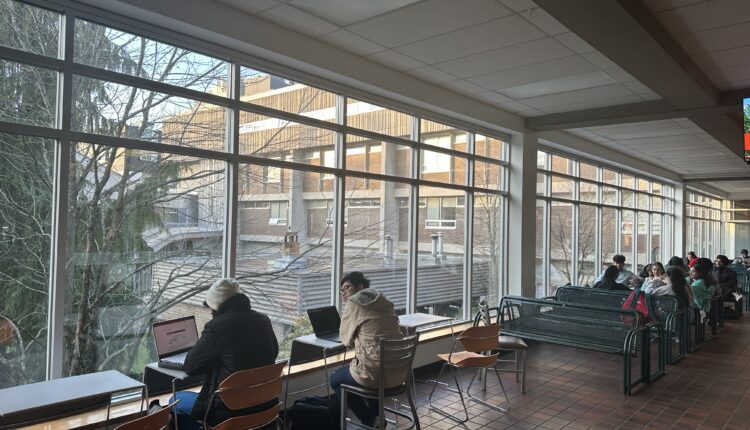 Langara students sit by windows in the seating area outside of the A Building cafeteria.