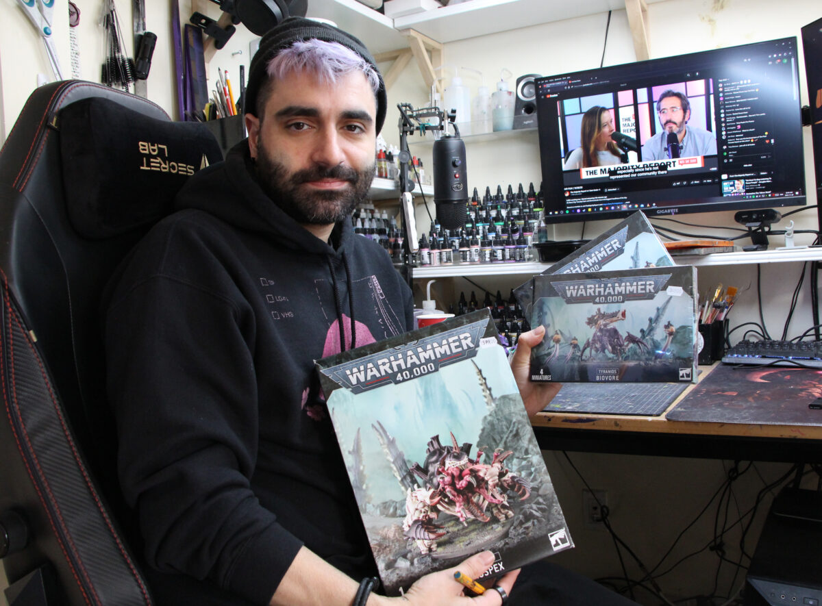 Jim Vesal displaying boxes of Tyranids from Warhammer 40k he received from a client to work on