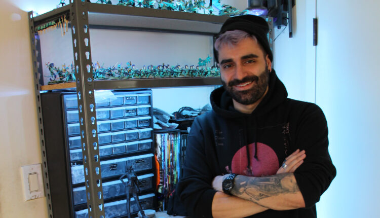 Jim Vesal next to his shelf that houses his supplies and army