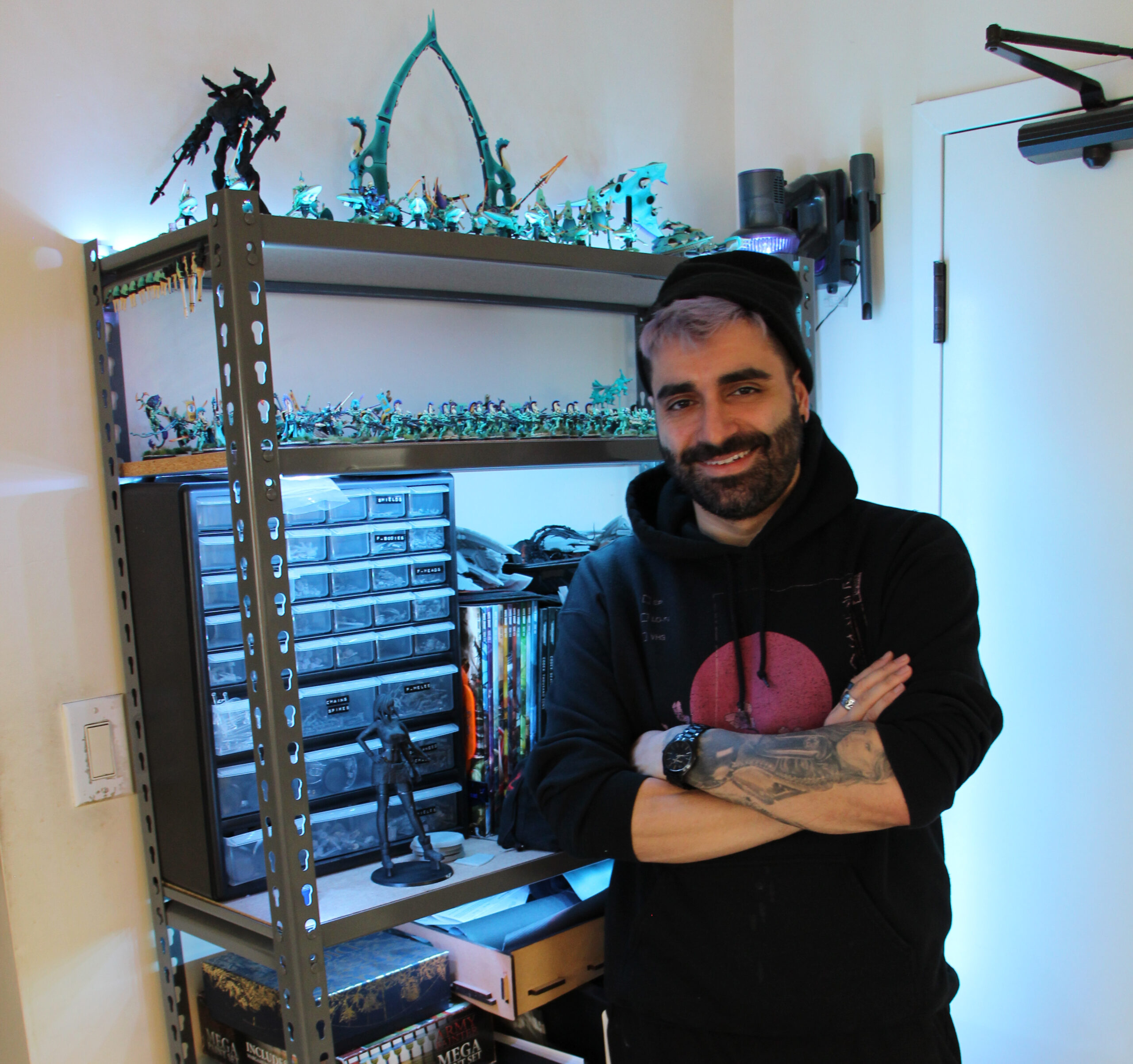 Jim Vesal next to his shelf that houses his supplies and army