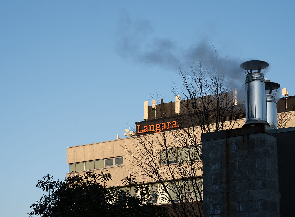 A picture of the Langara Building A, with smoke coming out from its top.